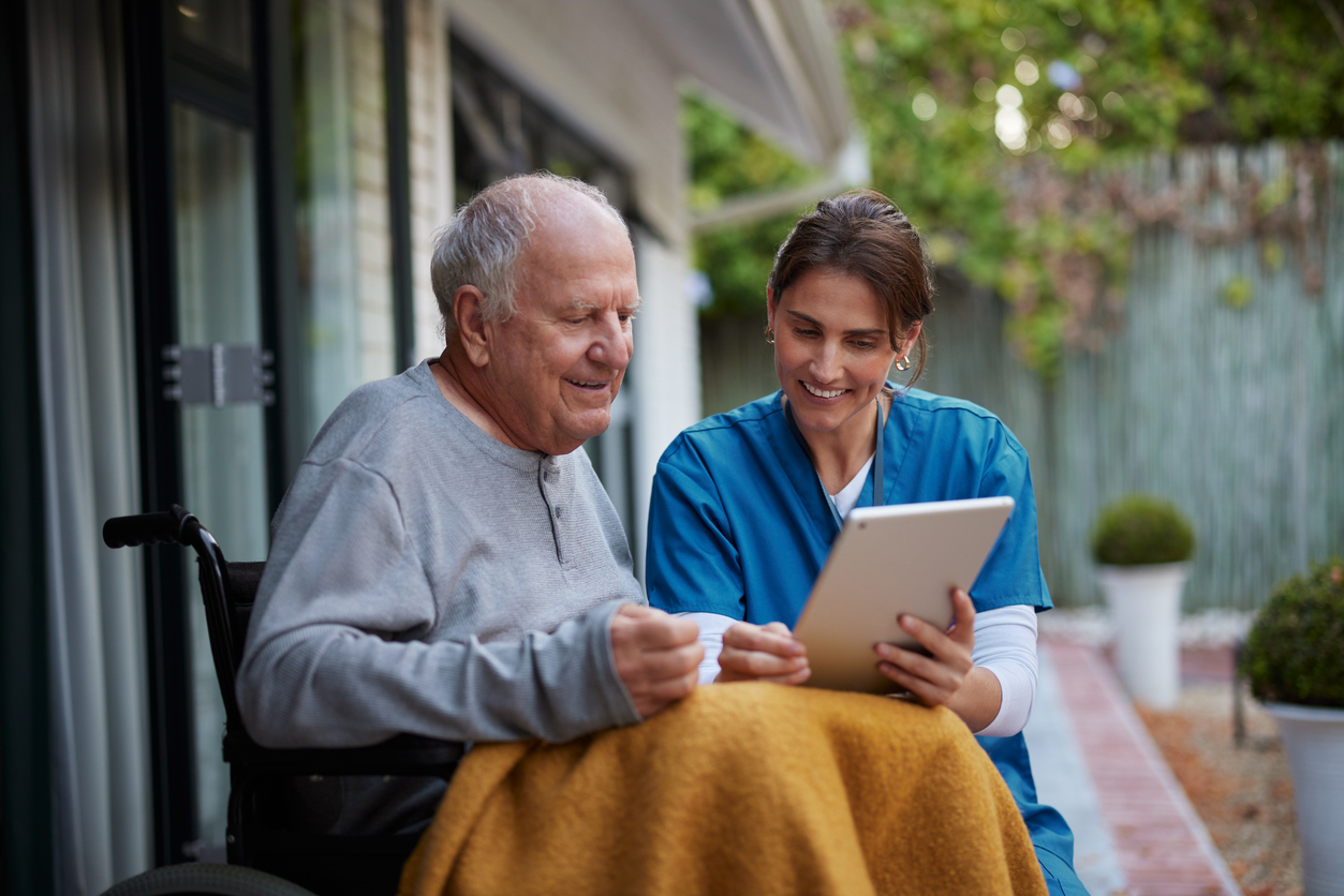 Senior and nurse reviewing tablet, illustrating senior care guidance and support.
